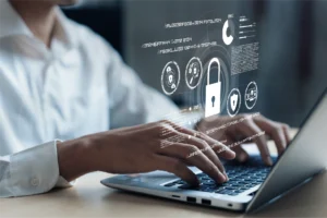 Person typing on a laptop with digital cybersecurity lock and analytics interface overlay.